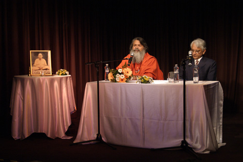 Swamiji shares the speaker\'s desk with Indian Ambassador to Czech Republic, H.E. Shree P.S. Raghavan